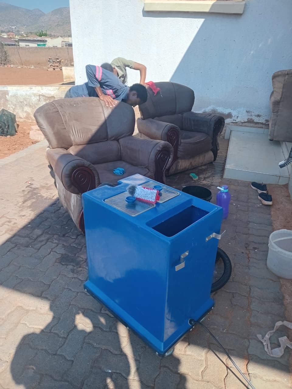 Tsela and Repo team using professional upholstery cleaning equipment